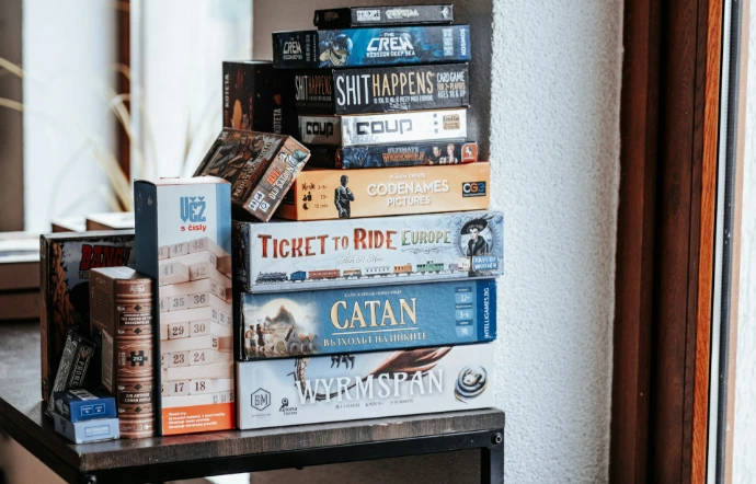 Board games are stacked on a shelf